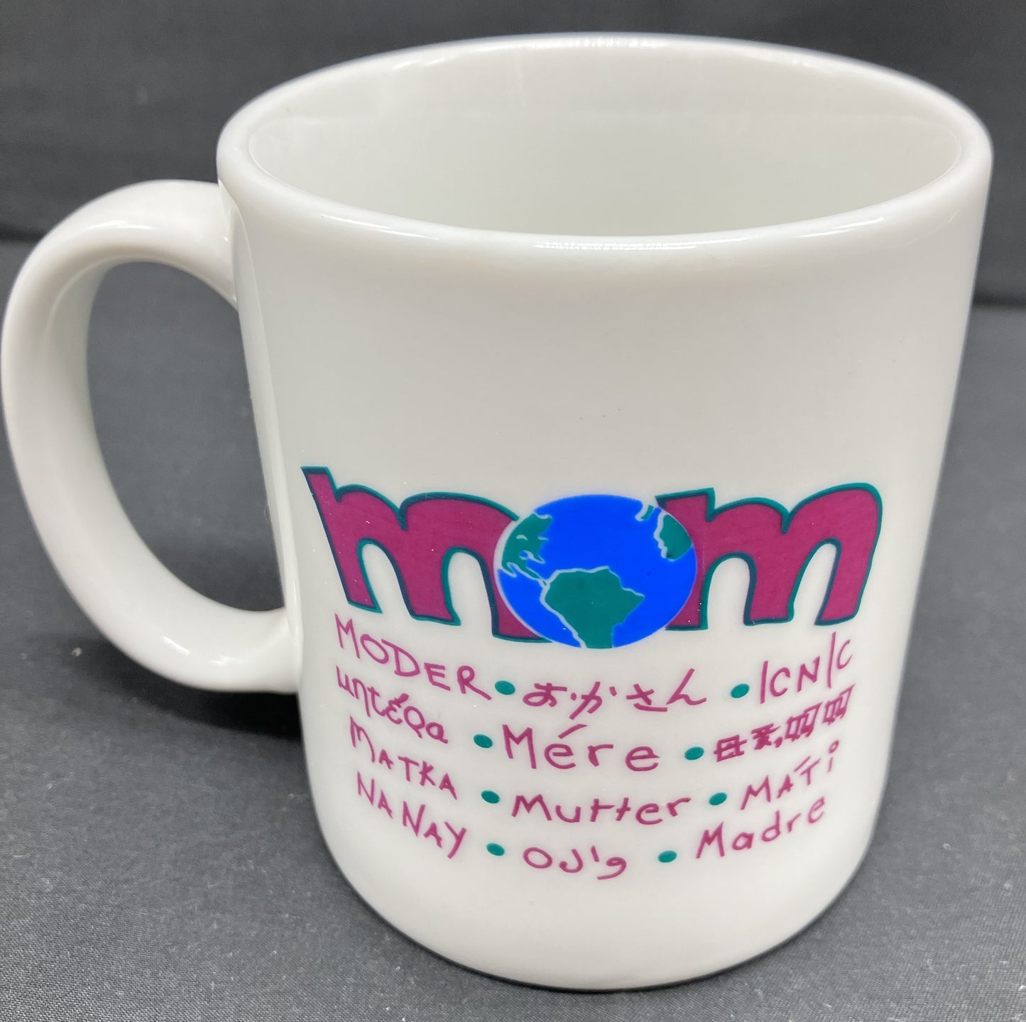 "Mom" mug with Mom printed in 12 additional languages, the "O" in Mom is a globe